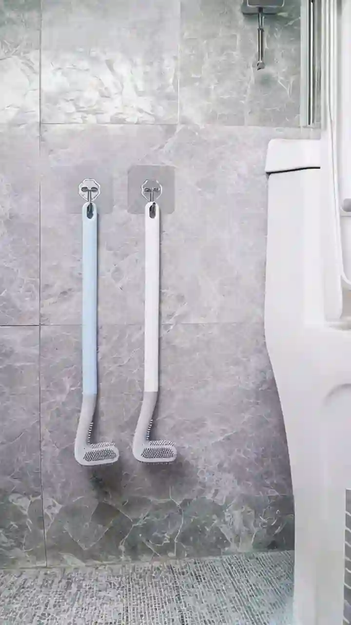 A modern and hygienic long-handled silicone toilet brush in its holder, a must-have tool for bathroom cleaning.