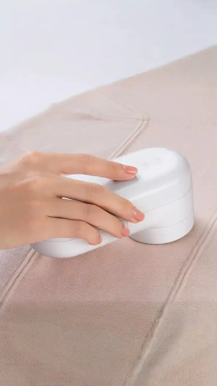 A reusable lint remover effectively collecting pet hair from a black sweater, an essential cleaning tool for pet owners.